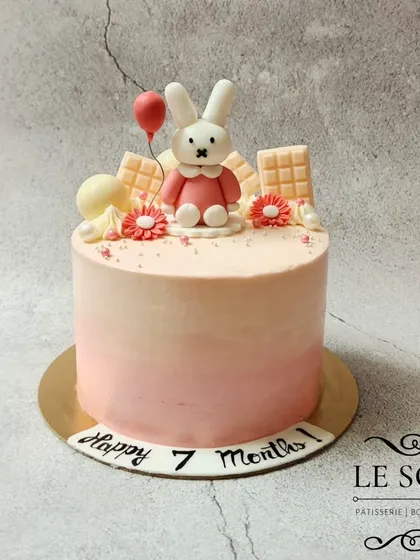A sweet and simple cake for a 7-month milestone. This half-kg Biscoff cake has a soft pink ombre finish and is topped with a cute fondant bunny holding a balloon.