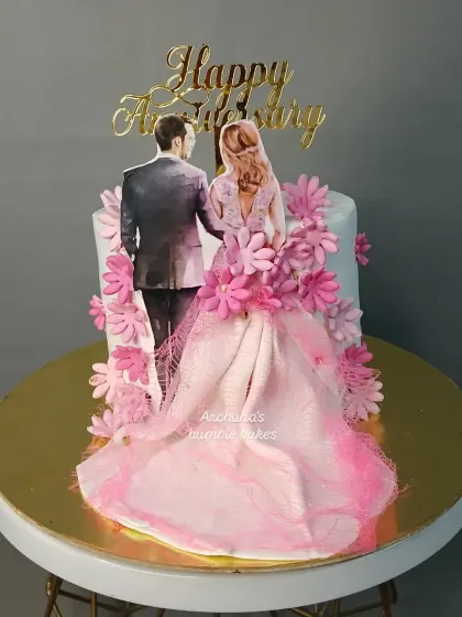 An anniversary cake with a lovely illustration of a couple and a flowing dress made of delicate wafer paper.