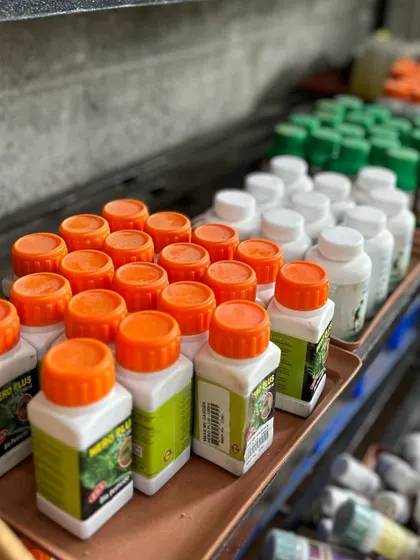 A glimpse of our stock of organic fertilizers and plant care products, neatly arranged with their orange, white, and green caps, creating a natural tricolor for our Independence Day post.