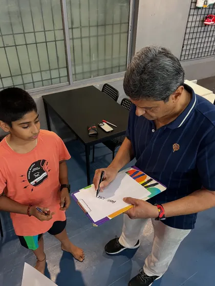A moment of mentorship as Prakash Padukone signs an autograph and shares a word of encouragement with a young, aspiring player.