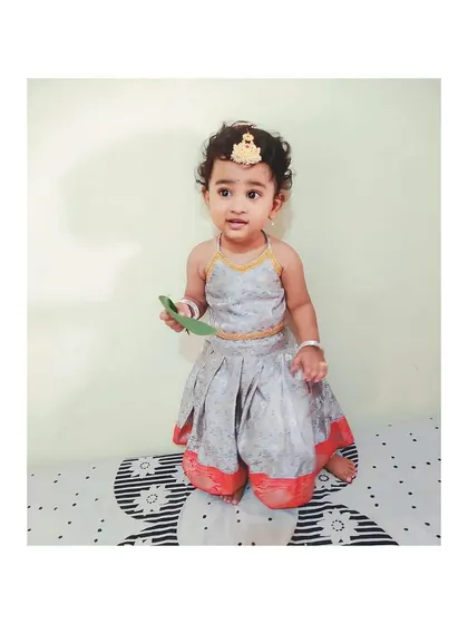 A tiny halter-neck lehenga set for a toddler. It's a modern take on traditional wear, designed to be comfortable for the littlest clients.