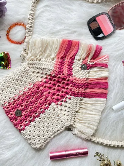 A different view of the pink geometric fringe bag, showing the magnetic button clasps that keep your belongings secure while maintaining a sleek profile.