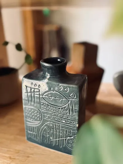 This hand-built flask-shaped vase features intricate carvings and a beautiful glaze. It's a great example of what you can create in our hand-building courses.