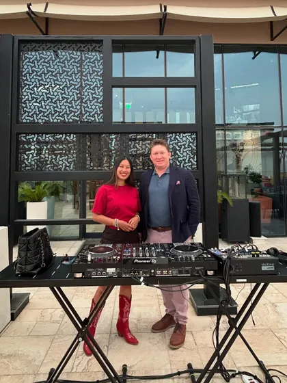 Standing with a hotel manager behind the decks, highlighting the collaborative nature of my work with luxury venues.