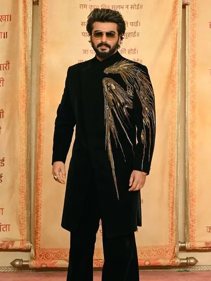 Arjun Kapoor in a statement black velvet indowestern piece with a dramatic gold embroidered wing design.