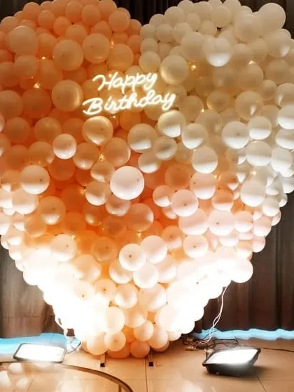 This heart-shaped balloon wall is a bold and romantic backdrop for birthdays, anniversaries, or Valentine's Day events. The integrated neon sign and uplighting make it glow beautifully in photos.
