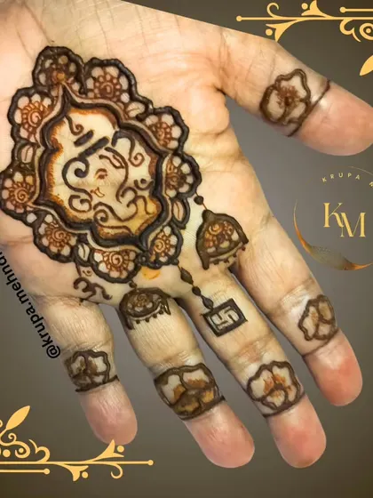 A minimalist Ganpati design with hanging jhumkas. This is a chic and modern way to wear your faith on your hands during festivals.