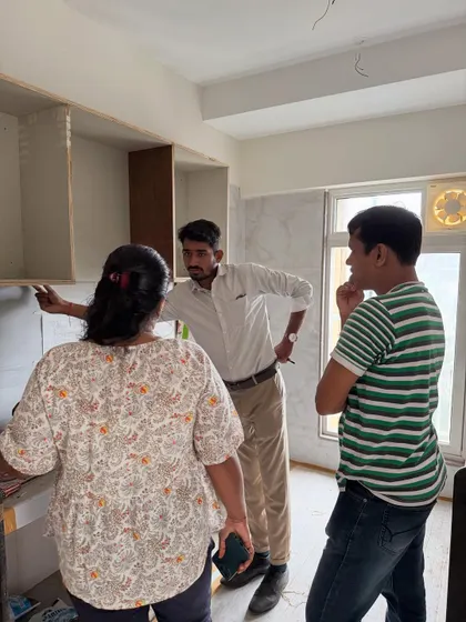 Explaining the layout of the kitchen cabinets to the clients as the woodwork progresses.
