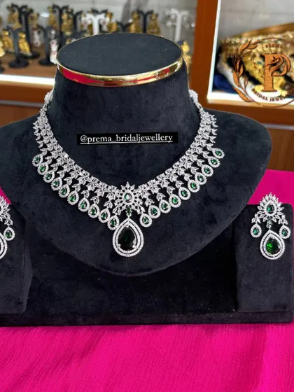 A beautiful AD necklace set with a large emerald-green center stone. This piece is perfect for adding a pop of color to your outfit.