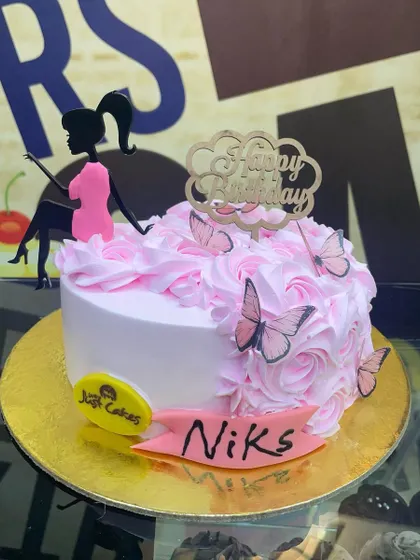 A charming 1.5kg cake with a sitting girl silhouette, pink rosettes, and butterfly accents.