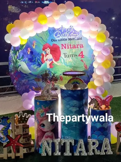 An enchanting 'under the sea' party with a Little Mermaid theme. This outdoor setup includes a custom backdrop and character cutouts.