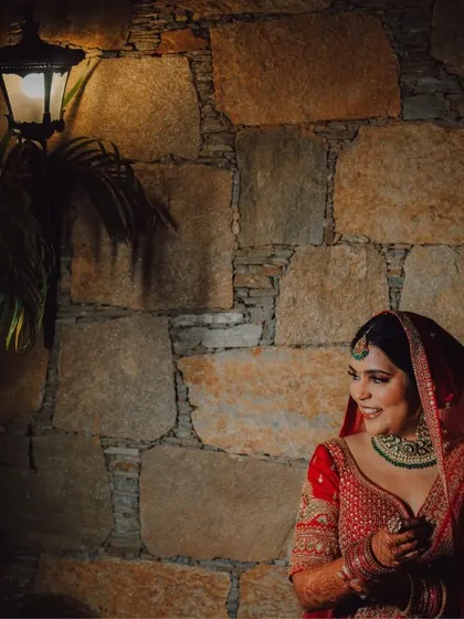 A stunning bridal portrait against a stone wall at a heritage property in Pushkar. We use the unique architecture of destination venues to create artistic and memorable shots.