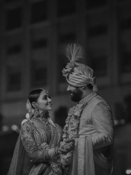 A classic black and white portrait of a bride and groom in their wedding attire. The timeless look and their loving gaze make this a forever kind of photo.