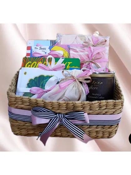 A luxury hamper for the mom-to-be, presented in a beautiful woven basket and filled with books, coffee, and other pampering items.