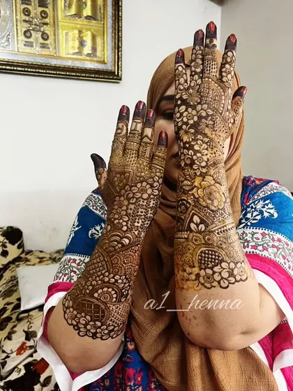 A lovely shot of a bride showcasing her elaborate henna, which is a central part of her wedding look.