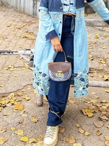 Focusing on the lower half of the outfit, this image highlights the interesting tie-detail on the jeans and the way the chunky sneakers complete the look.