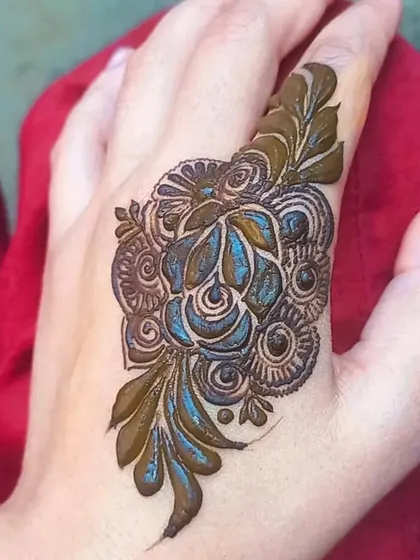 A single, detailed floral motif on the finger. A perfect tiny tattoo-style henna piece.