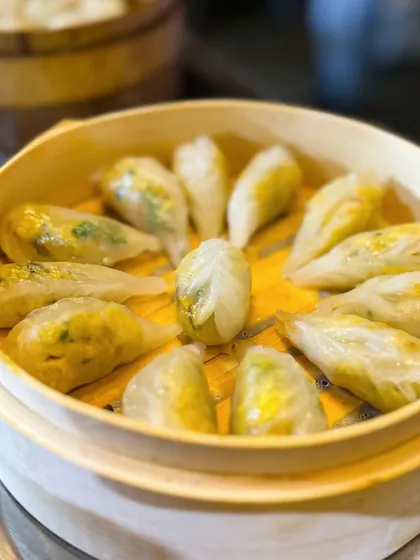 A beautiful arrangement of my handcrafted dim sum in a bamboo steamer. The translucent wrappers give a glimpse of the colorful vegetable fillings inside.