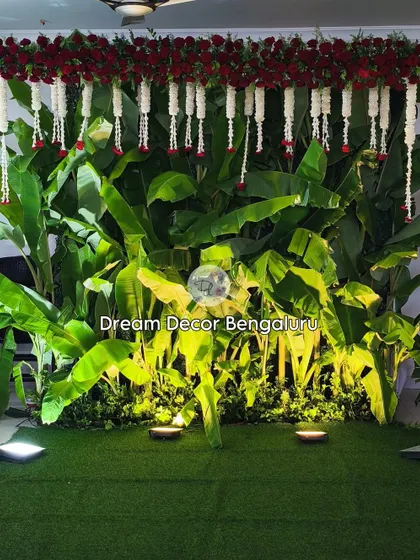 One of the most trending and budget-friendly traditional decors. A simple wall of fresh banana leaves, accented with red roses and jasmine garlands, creates a lush and authentic South Indian backdrop.