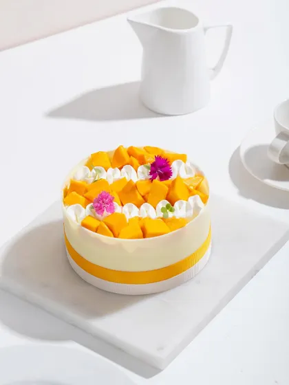 A full view of our white chocolate mango cake, a picture of simple, summery elegance.