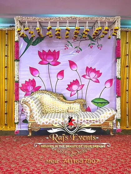 A unique and artistic backdrop for a baby shower. This stage setup features a hand-painted lotus theme, complemented by a regal chaise lounge for the mother-to-be.