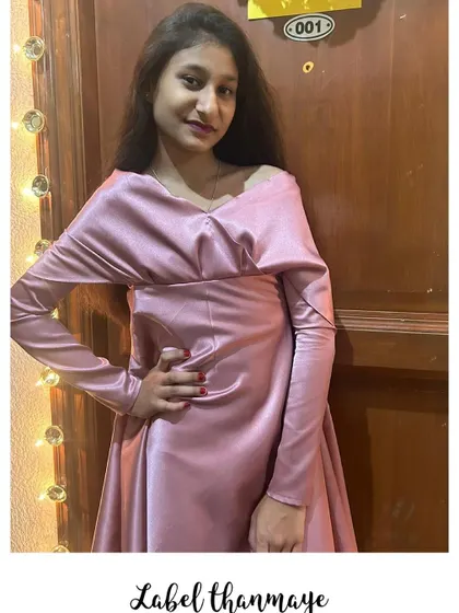 A chic and modern party dress in a dusty pink satin. The off-shoulder, draped neckline is a very elegant detail.