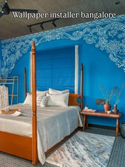 A custom mural in a modern style, featuring a traditional Indian floral arch design in white on a bold blue wall.