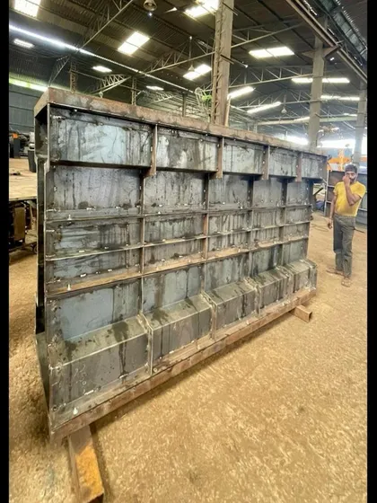 The large steel formwork, or mold, used to cast the precast concrete wall panels in the factory. The quality of this mold is critical to achieving a smooth, fair-faced concrete finish.