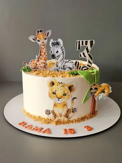 A simple yet adorable jungle cake for Rama's third birthday. This pineapple cake uses high-quality edible prints of safari animals for a clean and cute look.