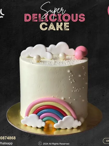 A simple and sweet rainbow cake. This design features a clean white buttercream base with a colorful fondant rainbow at the bottom and fluffy clouds on top.