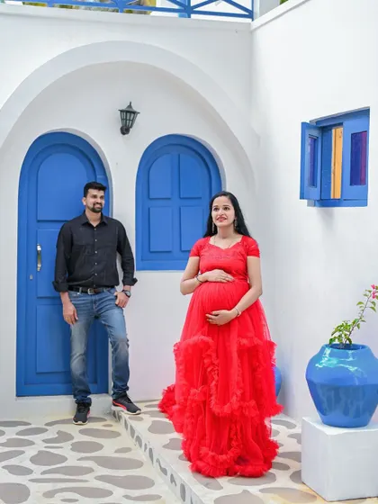 This setup gives a feel of a beautiful destination like Santorini, right here in the studio. The vibrant red gown pops against the classic white and blue.