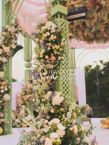 A close-up of the flowers adorning the green lattice structure of the mandap.