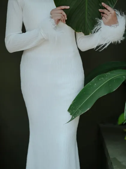 A creative fashion shot where the model's face is partially hidden by a large leaf. This adds an element of mystery and artistry.