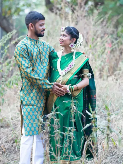 A traditional baby shower shoot, with the couple dressed in gorgeous green silk outfits. The floral jewelry and natural setting add to the celebratory feel.