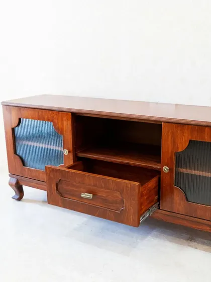 The central drawer of the TV console provides convenient storage for remotes and other small items.