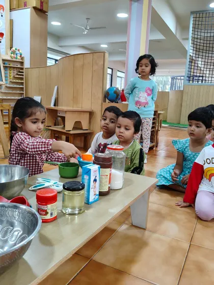 A child carefully lines up the ingredients before starting the baking process. This demonstrates the Montessori principle of order and preparation before beginning a task.