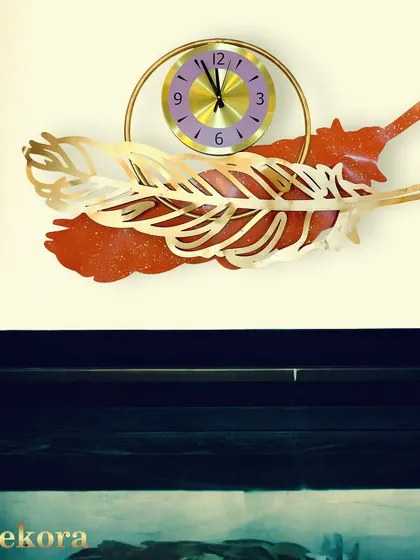 A unique clock featuring a golden feather design layered over a sparkling red base, adding a pop of color and texture.