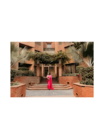 A distant shot showing the bride against the grand venue, creating a sense of scale and anticipation for the haldi ceremony.