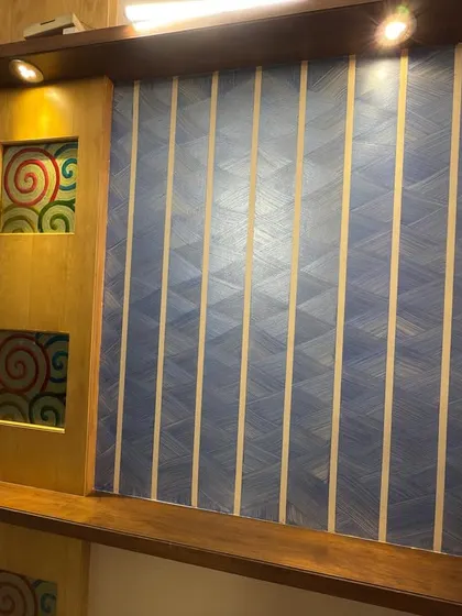 This custom media unit combines a rich wood polish with a unique textured wall panel. The warm downlights highlight the quality of the wood finish and the intricate pattern of the wall design.