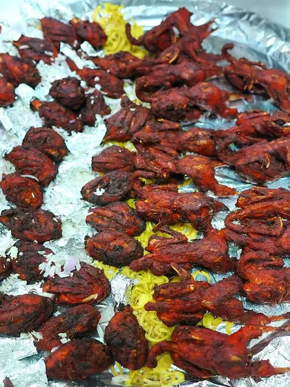 A platter of crispy fried Kaadai (quail), a delicacy that is always a hit with guests. We marinate it in special spices for a unique and delicious flavour.