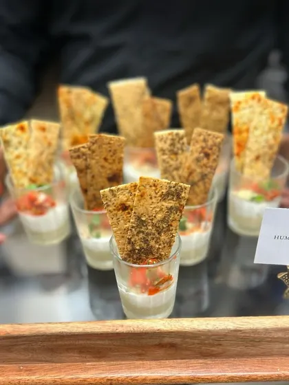 Hummus and labneh dip cups served with crispy lavash. This is a classic and crowd-pleasing appetizer, presented in individual portions for easy and hygienic enjoyment by guests.