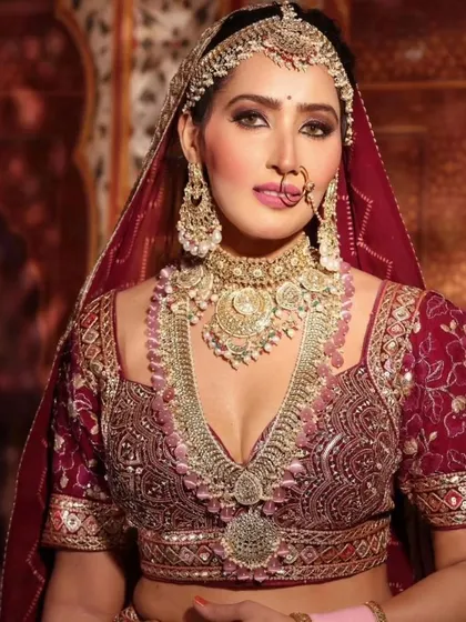 A bride in a deep pink lehenga, adorned with a matching pink-beaded Kundan jewellery set. A complete, regal look.