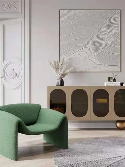 A uniquely sculptural accent chair in a vibrant green fabric. Its continuous, curved form creates a comfortable seat and a bold, artistic statement in this modern living space.