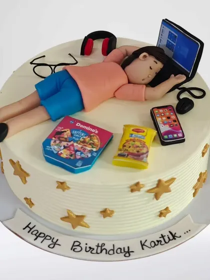 Another take on the workaholic theme, this cake shows a figure sleeping on his laptop. It's a relatable and funny cake for someone who works hard and loves their downtime with Domino's and Maggi.