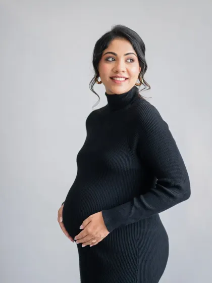 A beautiful solo portrait of the mother-to-be. Her joyful expression and the classic black dress create an elegant and sophisticated image that will be cherished for years.