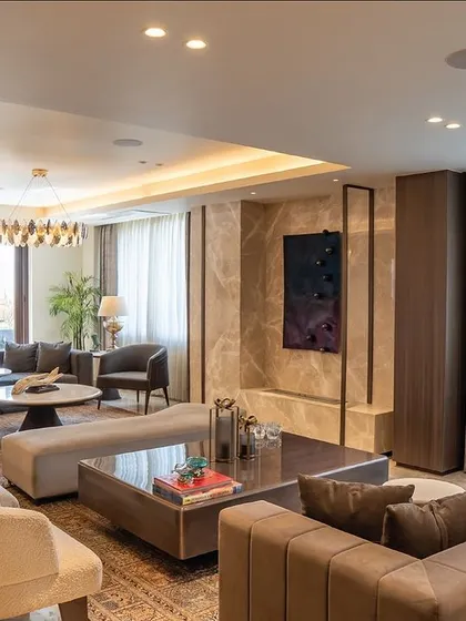 A large, open-plan living room designed for a family. The space is divided into multiple seating areas using our custom-made sofas and tables, ensuring both cohesiveness and functionality.