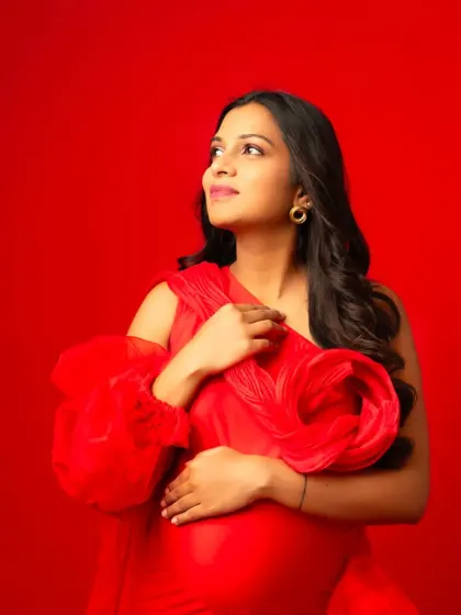 A close-up portrait in our red one-shoulder gown, showing off the intricate floral detail on the shoulder.