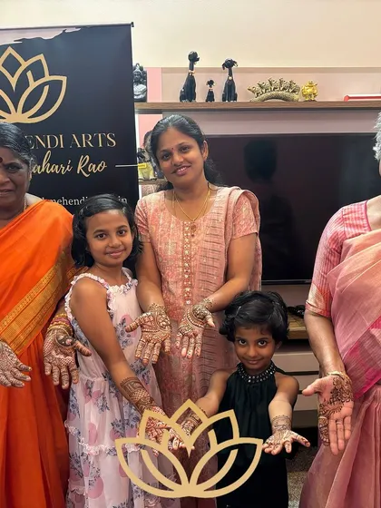Rashmi's family, from the youngest to the eldest, all showing their henna with happy smiles.