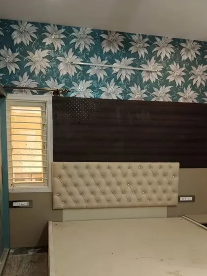 A bedroom accent wall with a bold floral pattern on a dark teal background. The design is modern and makes a strong statement.