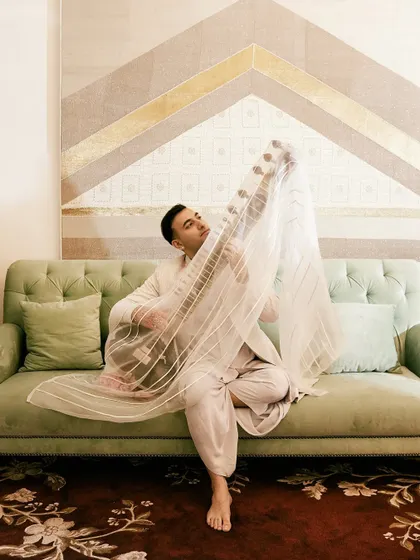 A playful and artistic shot on a couch, blending high fashion with a relaxed, intimate setting.